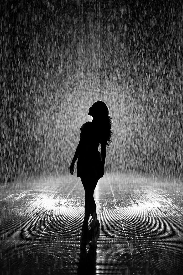 silhouette of woman under rain